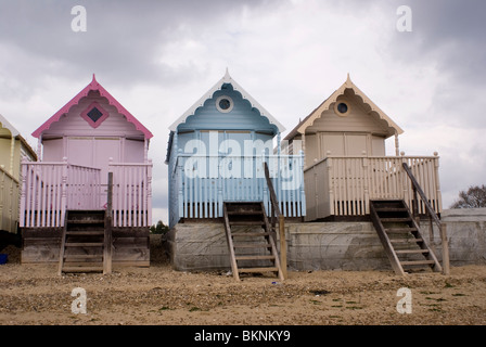 Three Brightly pastel coloured beach huts at West Mersea
