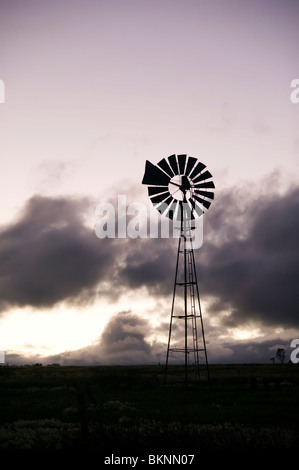 Windmill silhouetted against clouds Stock Photo