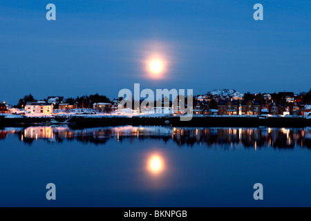 Houses reflected across the harbour of Ballstad fishing village on Vestvågøy, one of the Lofoten Islands in Norway Stock Photo