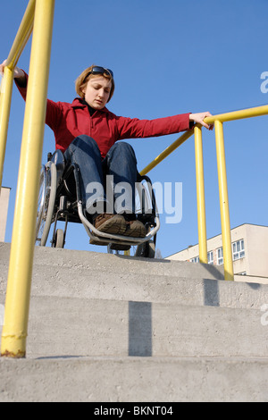 Handicapped woman on wheelchair going down the concrete stairs Stock Photo