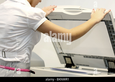 Young Worker Or Business Woman Standing And usind AN Office Photocopy Machine Printing Documents Stock Photo