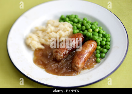Traditional British Warming Comfort Food Of Pork Sausages With Mashed Potatoes, Peas and Gravy Served On A Plate With No People