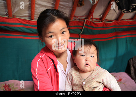 Mongolian mother holding her child in a ger Stock Photo