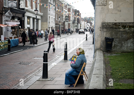 A female Big Issue seller on a street Stock Photo