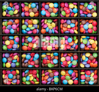 Smarties, sweets, pattern in an old wooden printers try Stock Photo