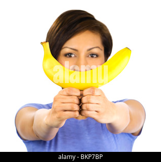 A young woman holds up a banana Stock Photo