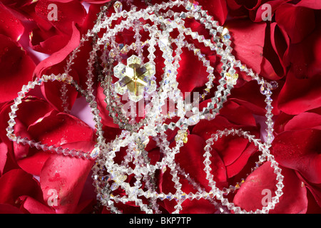 Shiny jewelry over bed or red rose petals Stock Photo