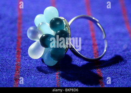 Colorful gem stones silver ring over vivid fabric background Stock Photo