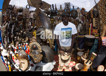 Stall holder playing an African drum in his stall at the Green Point market in Cape Town. Stock Photo