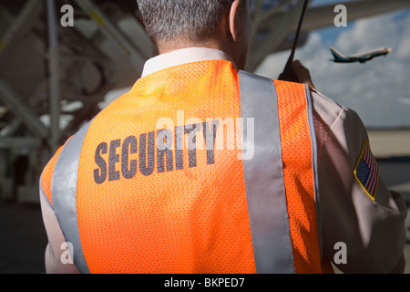 Security officer with walkie talkie radio in airport, back view Stock Photo