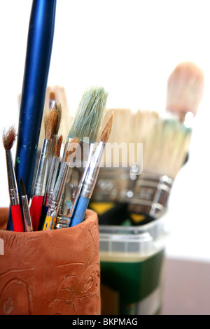 Artist used brushes clay pot isolated on white Stock Photo
