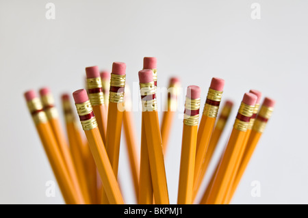 Numerous orange HB lead pencils in holder, on white background. Stock Photo