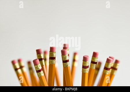 Numerous orange HB lead pencils in holder, on white background. Stock Photo