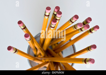 Numerous orange HB lead pencils in holder, on white background. Stock Photo