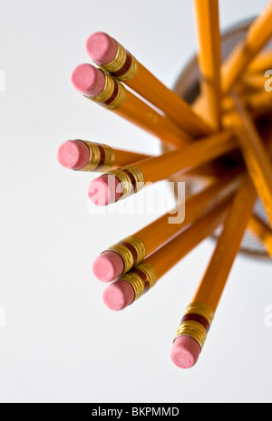Numerous orange HB lead pencils in holder, on white background. Stock Photo