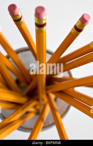 Numerous orange HB lead pencils in holder, on white background. Stock Photo