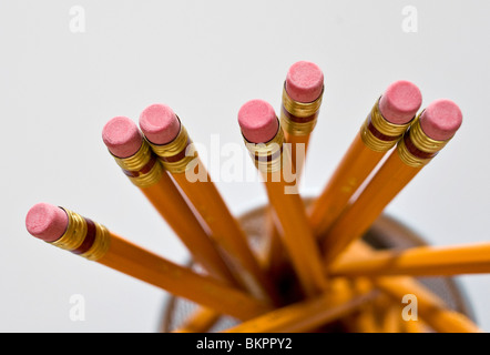 Numerous orange HB lead pencils in holder, on white background. Stock Photo