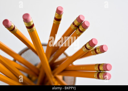 Numerous orange HB lead pencils in holder, on white background. Stock Photo