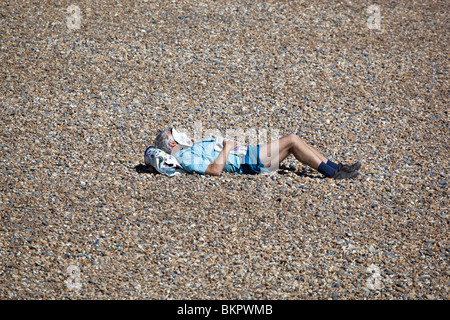 Man Sleeping on Brighton Beach East Sussex England UK Stock Photo
