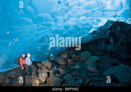Mother and daughter hikers explore an ice cave on the inside of the Mendenhall Glacier, Juneau, Alaska Stock Photo