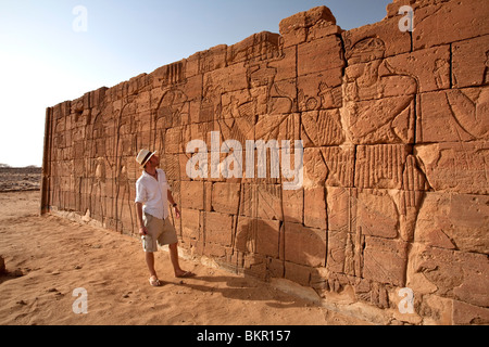 Sudan, Nagaa. A tourist gazes at the hieroglyphics on the Lion Temple at Nagaa. Stock Photo
