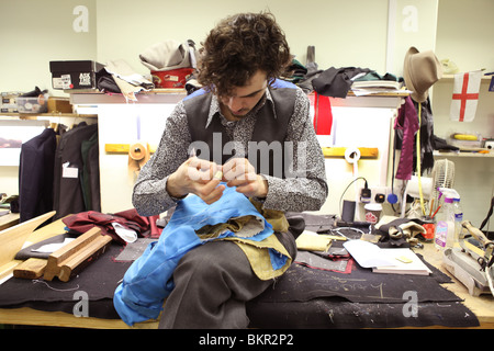 A Tailor in the workshop of Henry Poole. Savile Row, London. Stock Photo