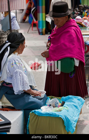 Ecuador, Two women negotiate the price of beads at Otavalo Indian Market. Stock Photo