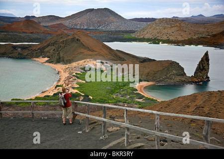 Galapagos Islands, A visitor photographs the view from the top of Bartolome Island looking across to Santiago Island. Stock Photo