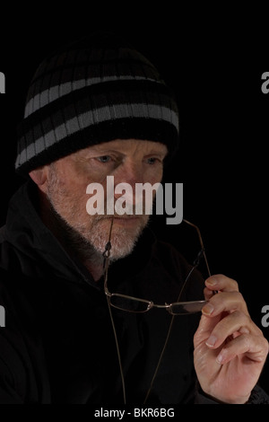 Mature man dressed in black deep in thought. Isolated. Stock Photo