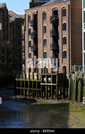 River Thames creek at low tide, converted Victorian warehouses originally used in the spice, tobacco and commodity trades Stock Photo