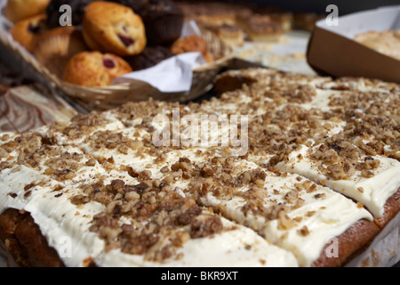 large carrot cake cut into slices on a bakery stall at an outdoor market Holywood County Down Northern Ireland UK Stock Photo