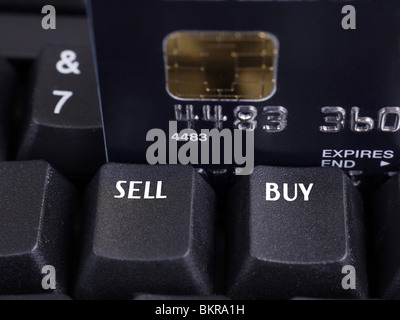 Closeup of two black keyboard keys with Sell and Buy words and microchip credit card in the background Stock Photo