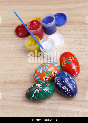 Easter eggs, paint tubes and paintbrush on wooden table Stock Photo