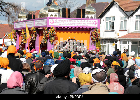 Sikh followers behind the Sri Guru Granth Sahib (Sikh holy book) at the Vaisakhi Nagar Kirtan (procession), Hounslow, UK. Stock Photo