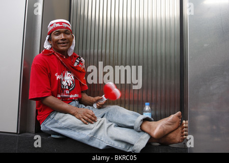 A Red shirt demonstrator campaigning for the return of disgraced PM Thaksin Shinawatra, takes a rest in central Bangkok. Stock Photo
