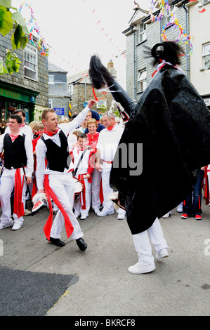 a young man dances with the ' red oss ' on ' obby oss ' day in padstow, cornwall, uk Stock Photo