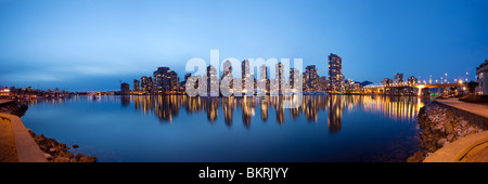 False creek framed by the Vancouver Seawall reflects the lights of Yaletown apartment complexes and BC Place Stadium on the Vancouver downtown Skyline Stock Photo