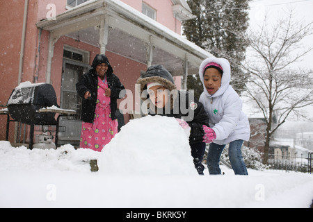 Mother and children prepare to build a snowman. Stock Photo