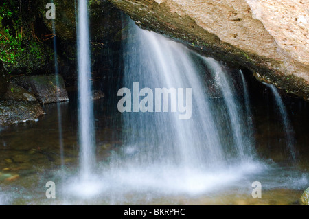 Small waterfall under boulder in Sour Milk Gill, Easedale, near Grasmere in the English Lake District Stock Photo