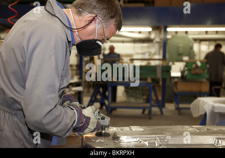 factory floor worker using a angle grinder on metal surface Stock Photo