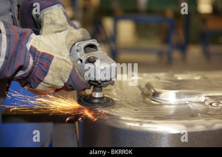 man using a angle grinder on metal surface with sparks Stock Photo