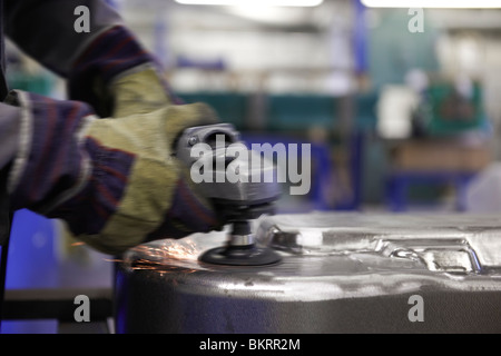 man using a angle grinder on metal surface with sparks Stock Photo