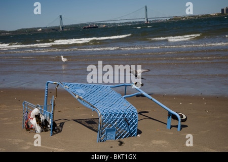 An abandoned shopping cart buried on the beach of Coney Island creek in Brooklyn in New York