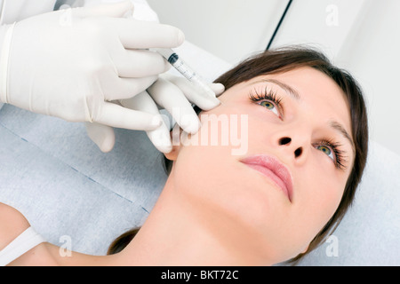 young caucasian woman receiving an injection of botox from a doctor Stock Photo