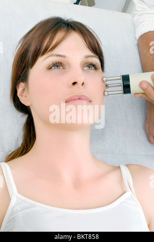 portrait of a young caucasian woman receiving electrostimulation lifting Stock Photo