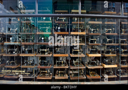 A shop window display full of old fashioned Singer sewing machines, a fashion  clothes shop in Brighton, Sussex UK Stock Photo