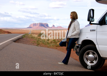 Female tourist leaning on Cruise America RV campervan Monument Valley Highway 163 Arizona Utah border USA Kim Paumier MR Stock Photo