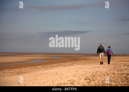 middle aged couple walking on beach Stock Photo