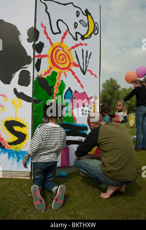 Families at Celebration of World 'Fair Trade' Day, with people Painting Wall Mural in La Villette Park, Street Art Stock Photo