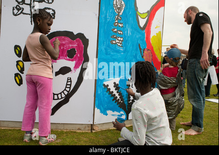 Children at Celebration of World 'Fair Trade' Day, Painting wall Mural in La Villette Park, Street Art Stock Photo